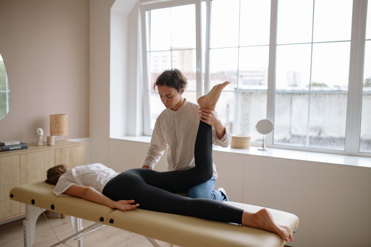 Therapist guiding an assisted leg stretch, sports massage Kharghar, Sector 11