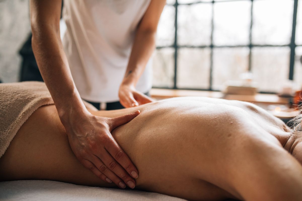 Gentle Swedish massage strokes on a towel-draped guest, swedish massage Nerul, Navi Mumbai