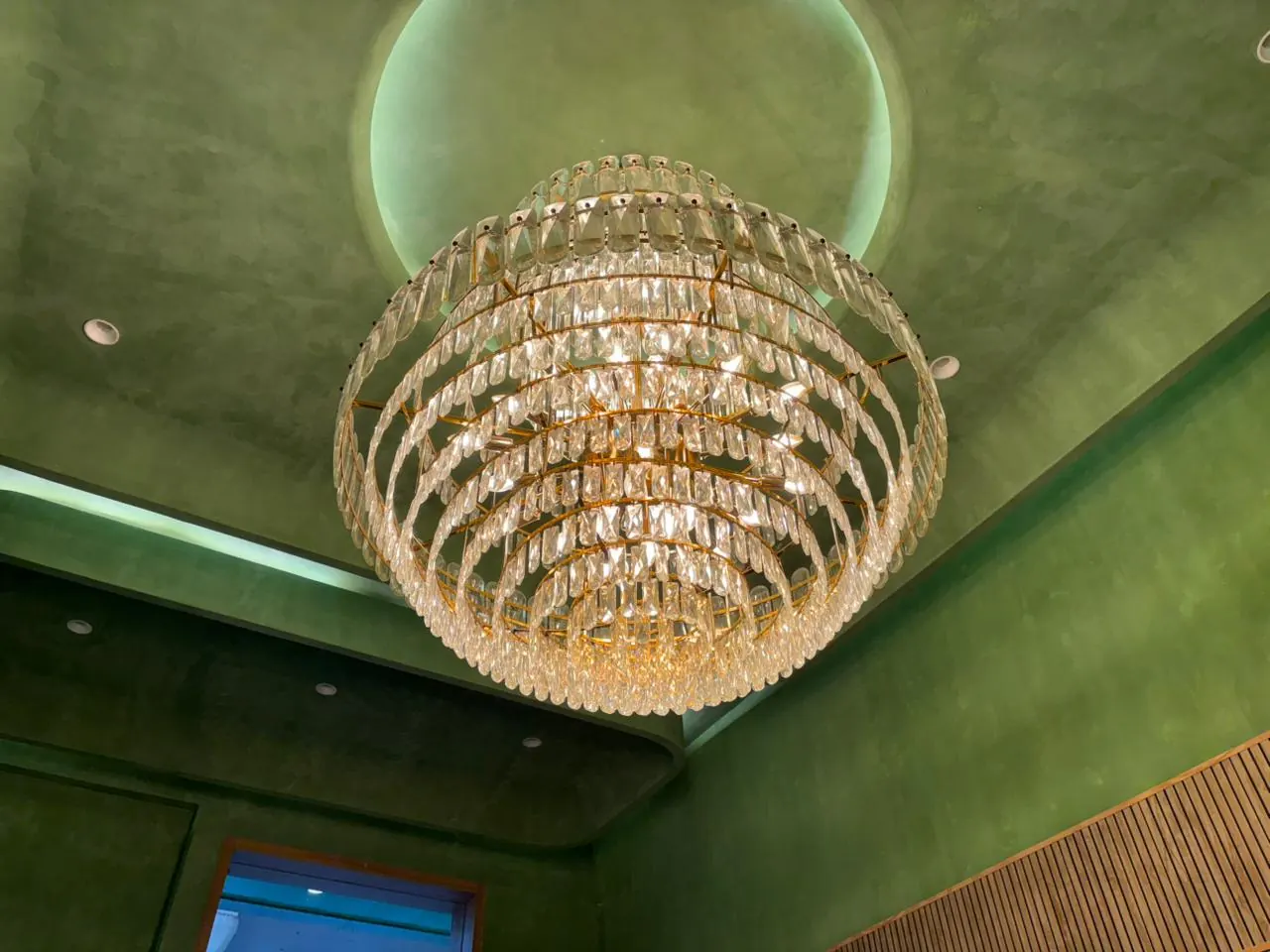Detail of the Sector 11 chandelier against the green lacquered ceiling
