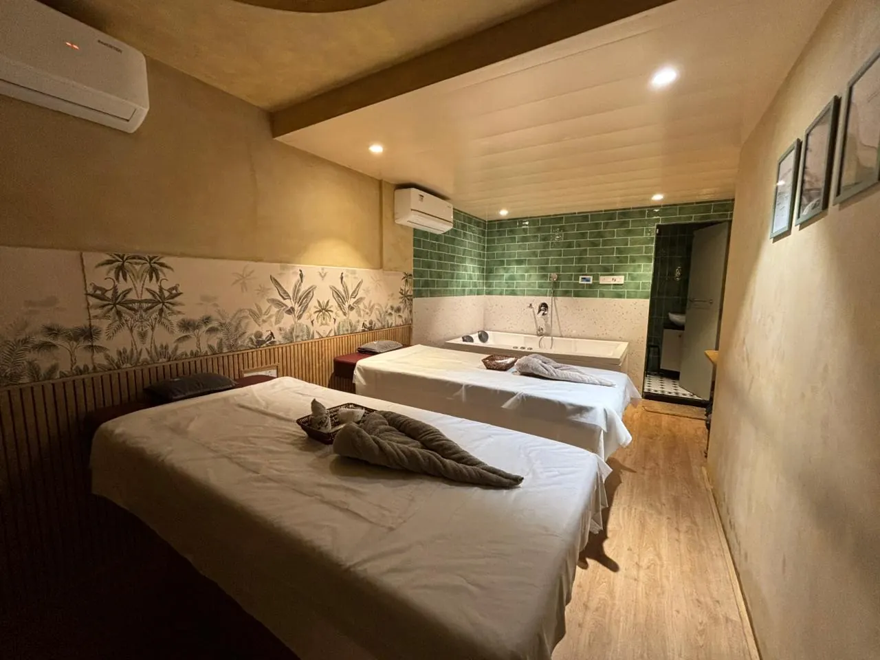 The Sector 11 couples suite, twin beds against a botanical tiled mural