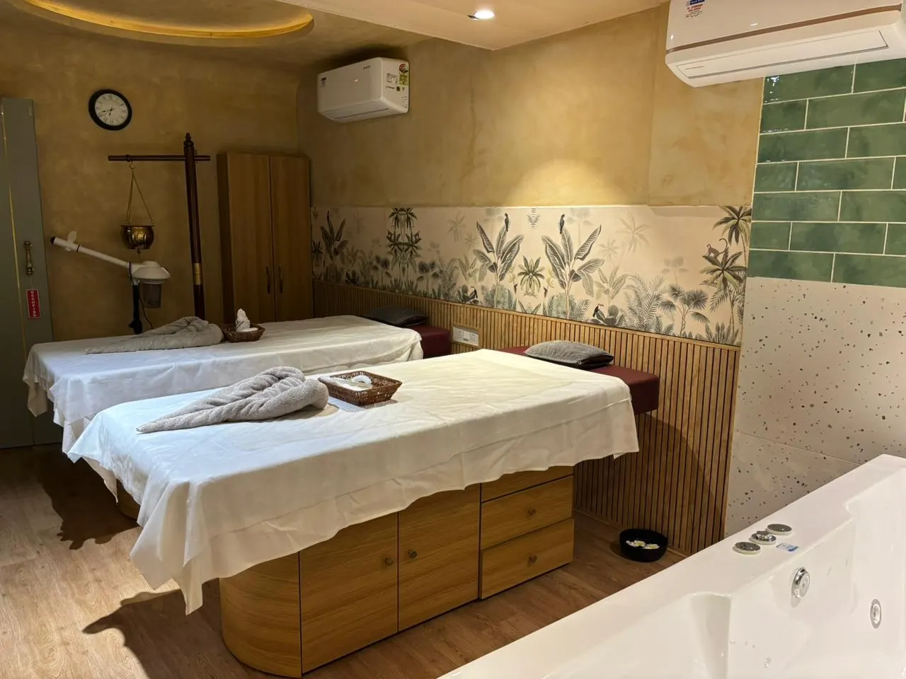 Twin treatment beds dressed beneath the botanical mural at Sector 11