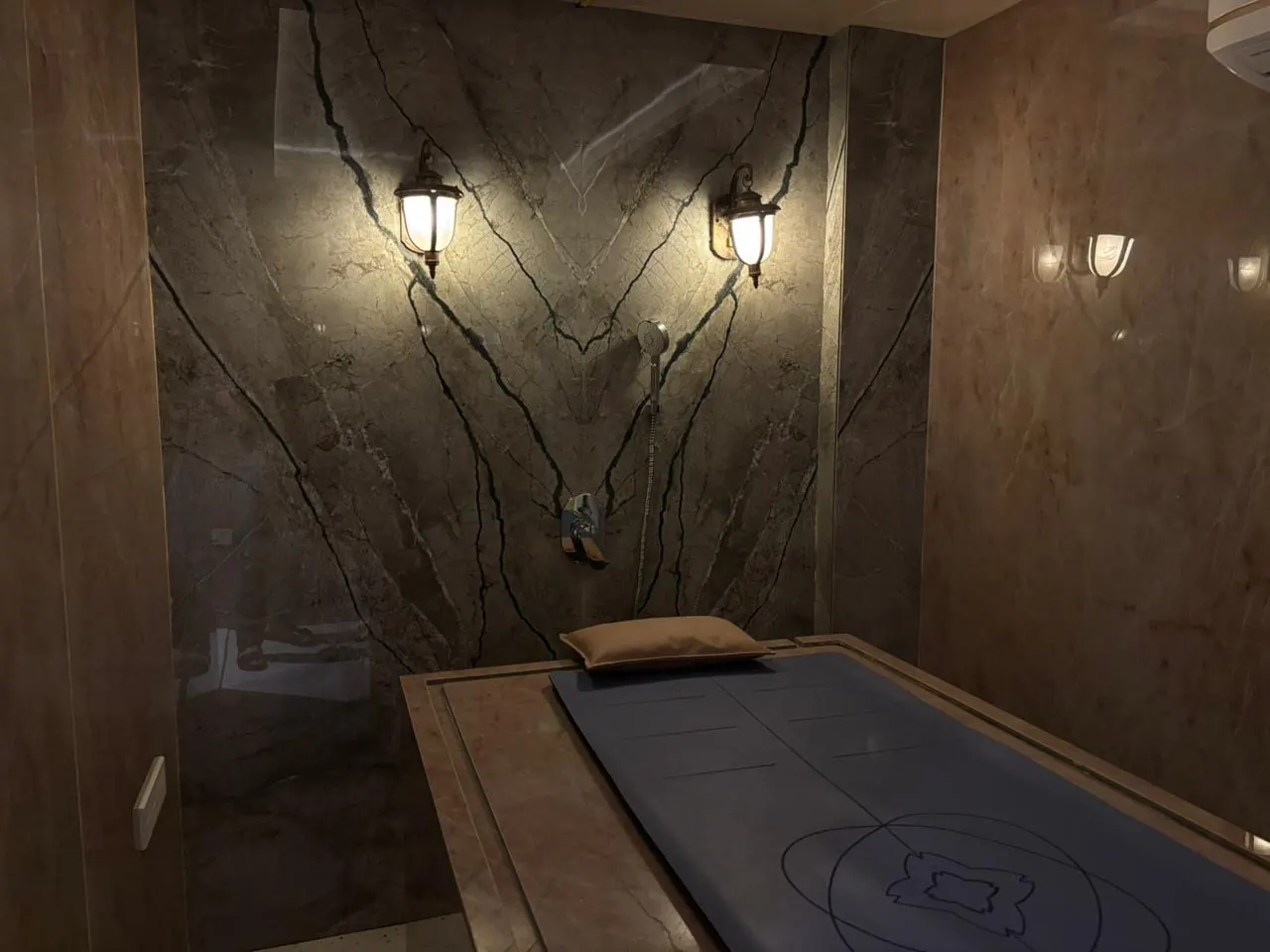 The marble Hamam chamber at Sector 11, lantern sconces above the heated slab