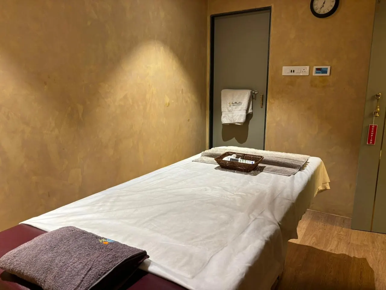 A brass tray of oils set at the foot of a dressed bed at Sector 11