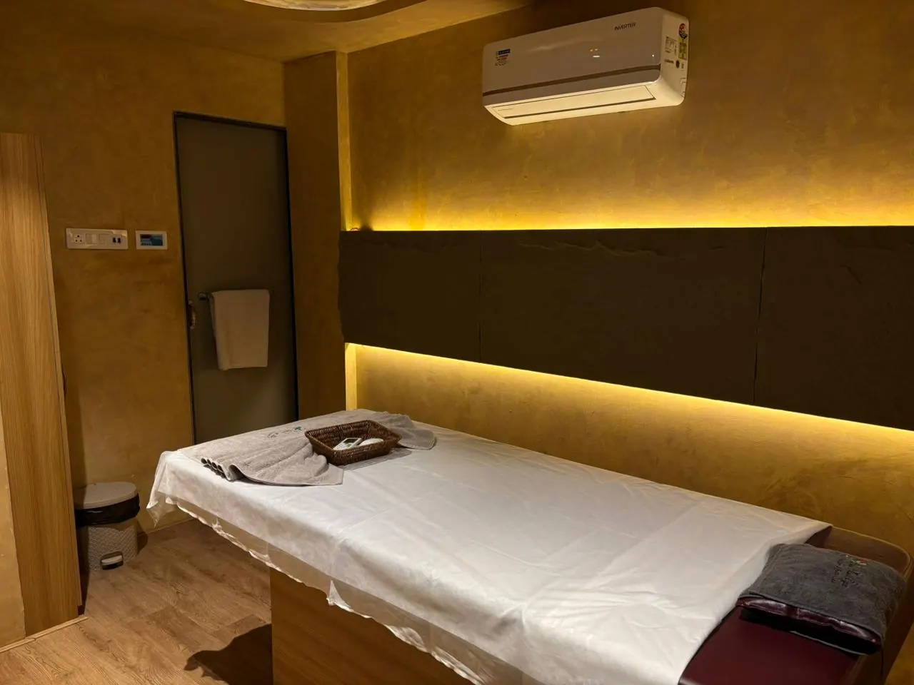 A Sector 11 treatment room lit amber, towels folded at the foot of the bed