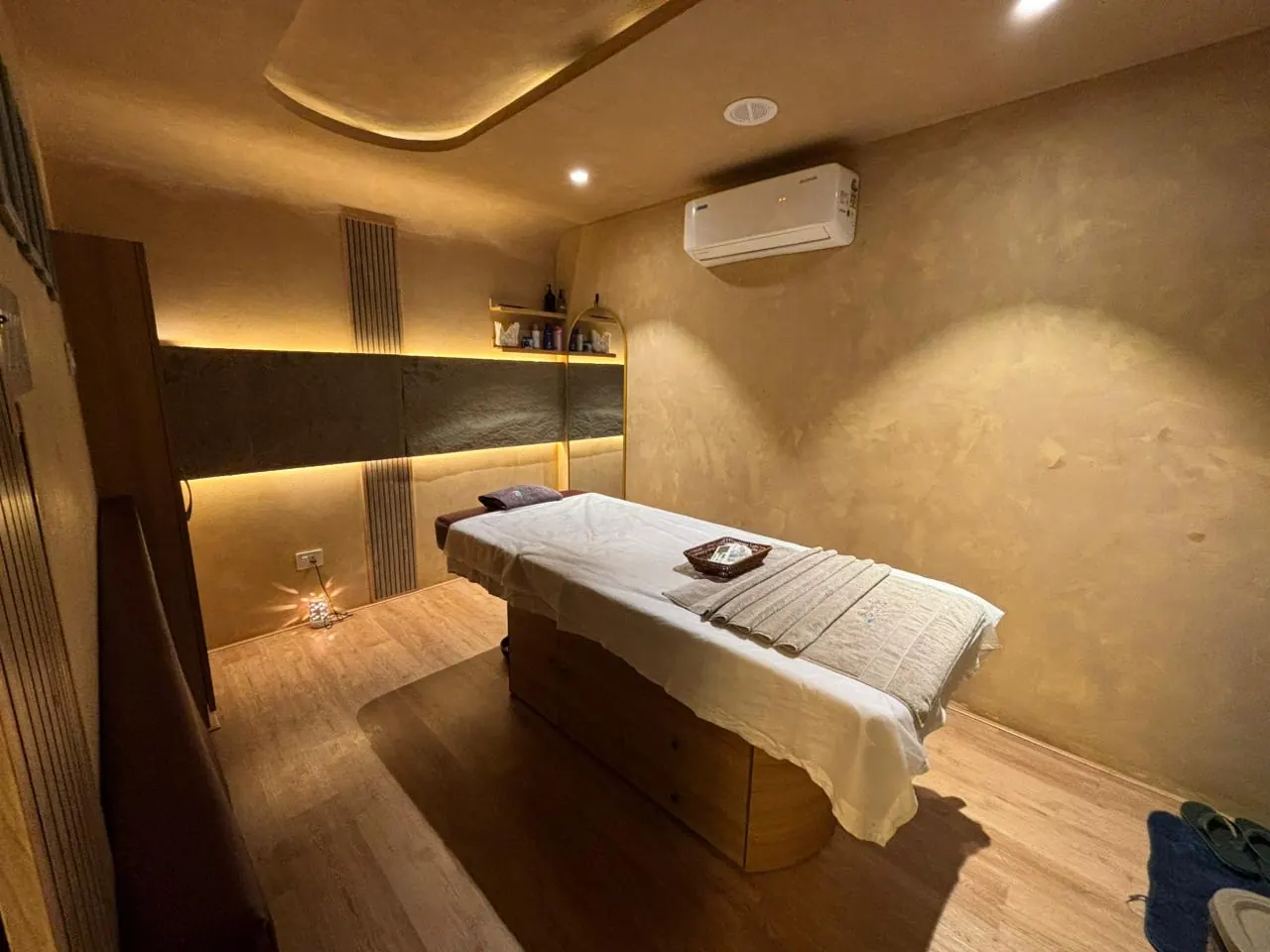A Sector 11 treatment room, oils and folded linen on the shelf beside the bed