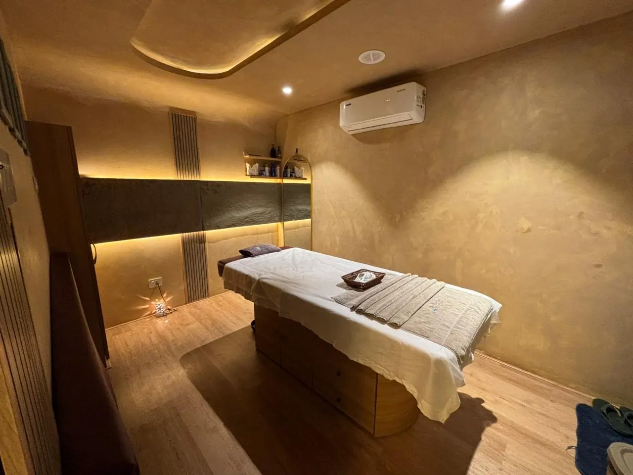 A single treatment room at Sector 11, bed made up under warm cove lighting