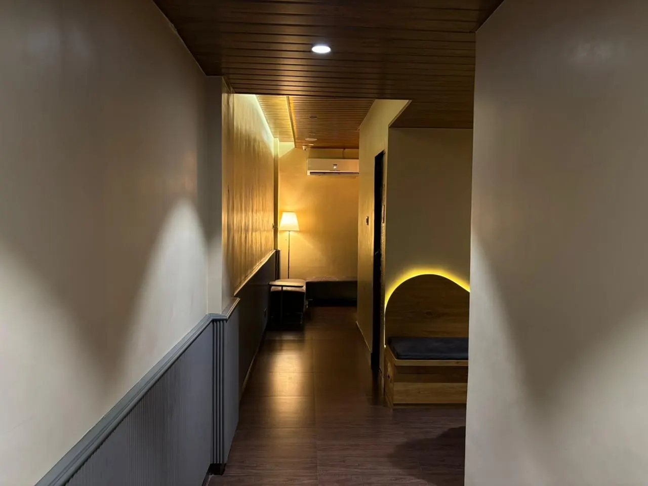 The warm-lit corridor at Sector 7, an arched rest nook off to one side