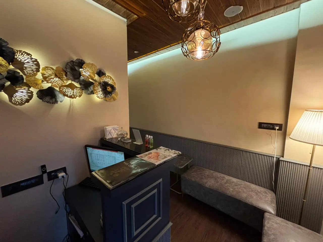 The Sector 7 reception lounge, a cushioned bench beneath gold leaf wall art