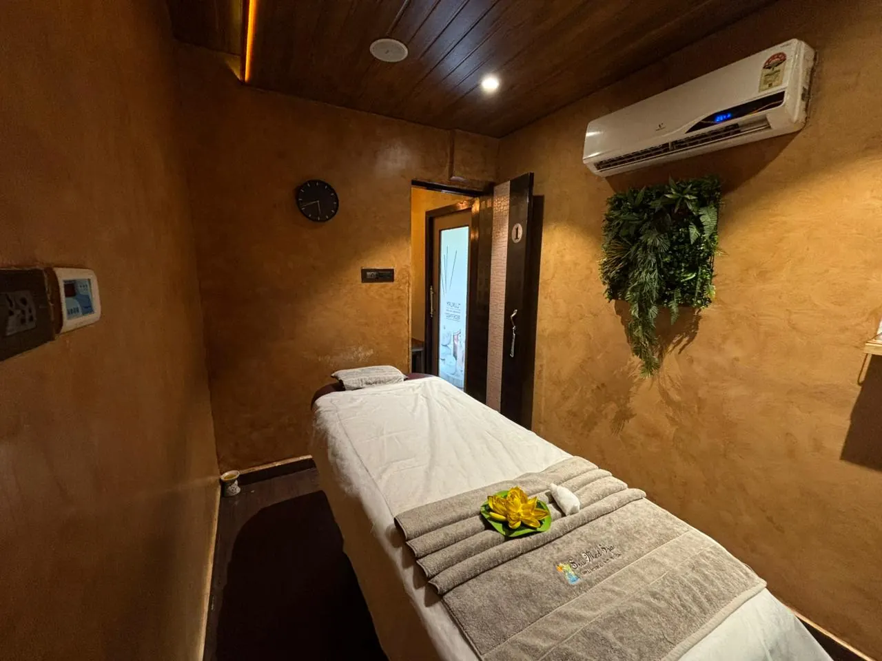 A Sector 7 treatment room, bed dressed with folded towels and a fresh flower