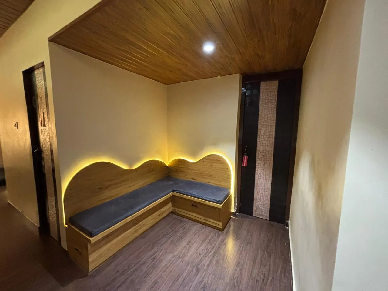 The wood-panelled waiting nook at Sector 7, lit by a warm arch